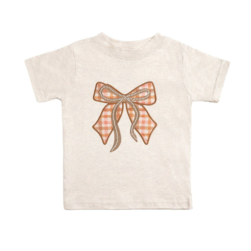 Natural Heather T-shirt with a cinnamon plaid bow patch featuring pearl accents.