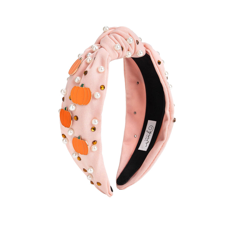 Pink headband adorned with small pumpkins, pearls, and rhinestones.