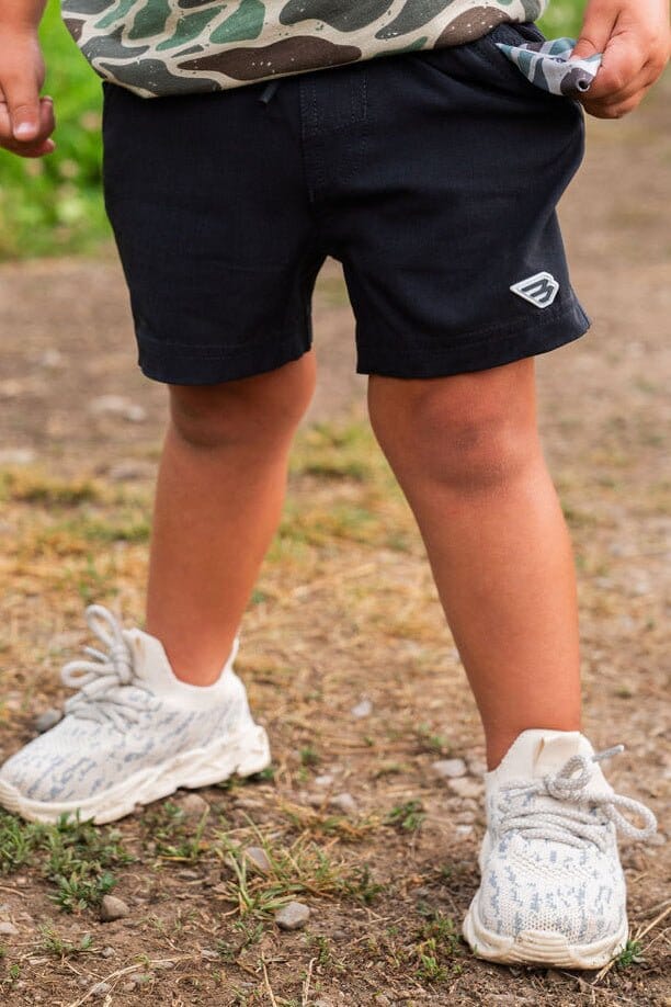 Child wearing Burlebo Youth Athletic Shorts in Heather Black with a retro duck camo liner.